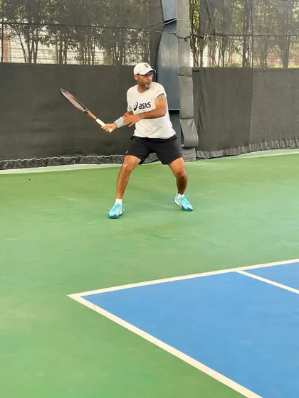 A player holds a solid ready position, demonstrating excellent balance and preparation for the next shot.