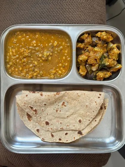 A simple and healthy meal of chapati with whole green gram dal and sautéed brinjal.