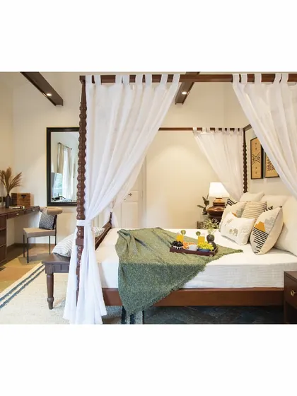 For this tropical-themed bedroom, we designed a classic four-poster bed with soft, buttery curtains to create a dreamy, resort-like feel. The design includes a matching study desk and bedside tables, all crafted from solid wood.