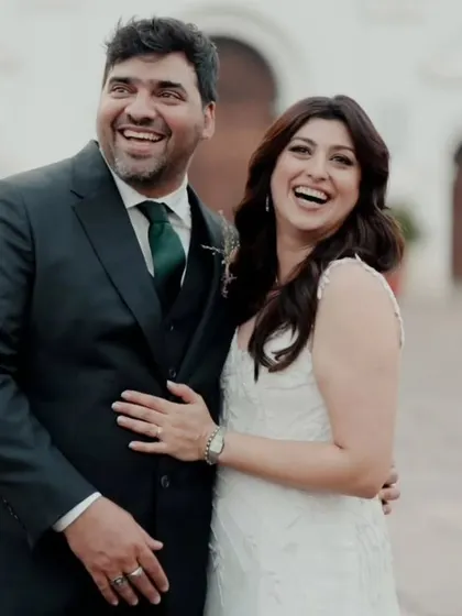 Laughter and love. This candid shot shows the bride and groom sharing a happy moment, her natural makeup and soft hair looking effortlessly beautiful.