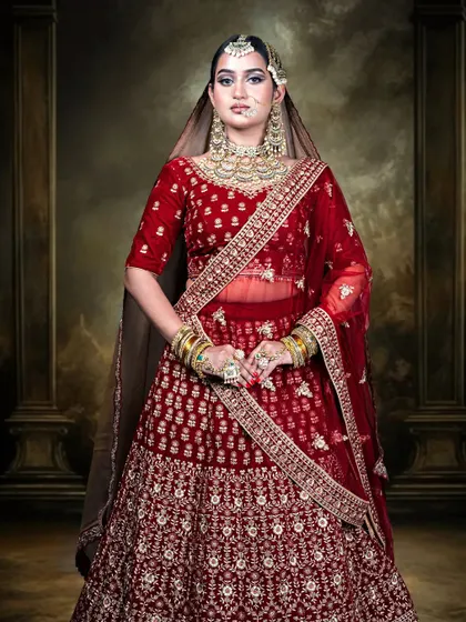 A regal portrait in a classic red bridal lehenga, inspired by the timeless beauty of Heeramandi. This outfit is designed to make you feel like a queen, with its rich color and exquisite detailing perfect for your wedding album.