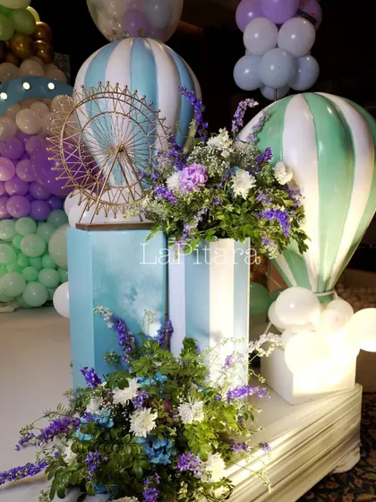 Elegant carnival decor details, including hot air balloon models, a miniature Ferris wheel, and fresh floral arrangements.