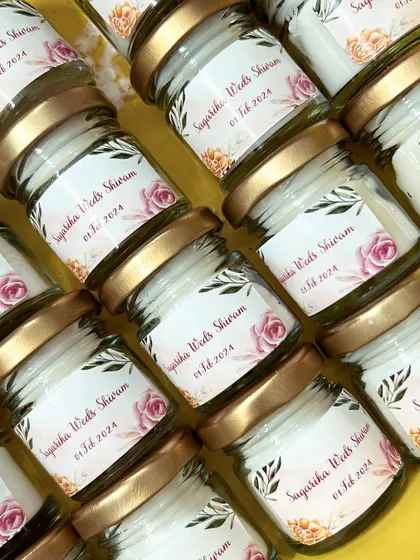 An aerial view of the wedding favor candles for Sagarika and Shivam, neatly arranged and ready for the next step of packaging.