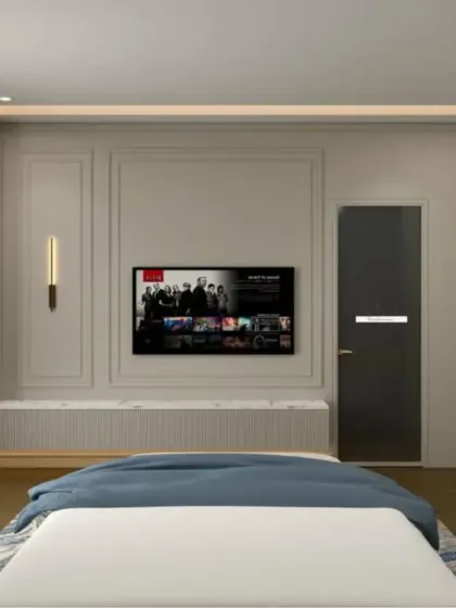 The TV wall in this blue-themed bedroom features elegant molding and a built-in display shelf, combining classic and modern design elements.