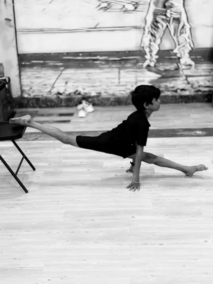 A student demonstrates a perfect split, a result of consistent training in our contemporary and flexibility classes. We help you unlock your body's potential.