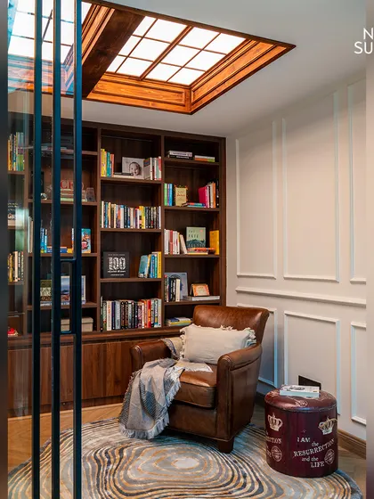 We designed this personal library to be a cozy escape. It features floor-to-ceiling wooden bookshelves, a comfortable leather armchair, and a large skylight that floods the space with natural light, making it perfect for reading.