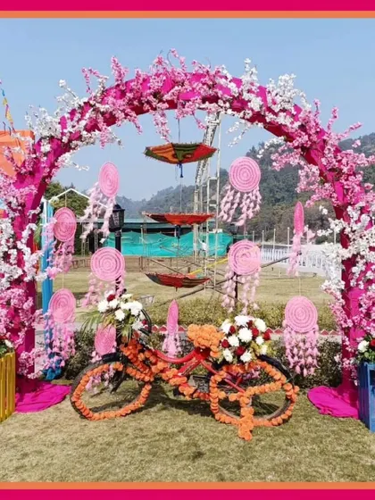A whimsical Mehendi photobooth featuring a floral arch, dreamcatchers, and a decorated bicycle, perfect for capturing fun memories.