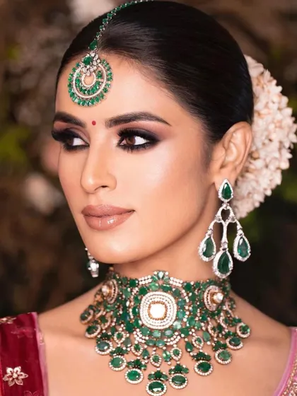 A close-up of a classic bridal look with a bold, black smokey eye and emerald jewelry. I teach the importance of balancing a dark eye with a neutral lip and radiant skin.