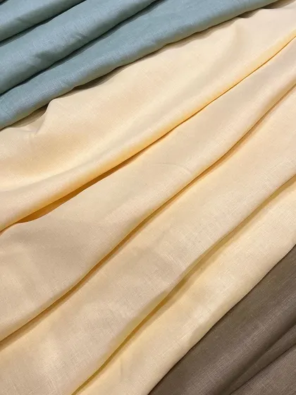 The soft drape and subtle colors of our pure linen collection. These fabrics are available in-store for you to choose from for your custom-tailored garments.