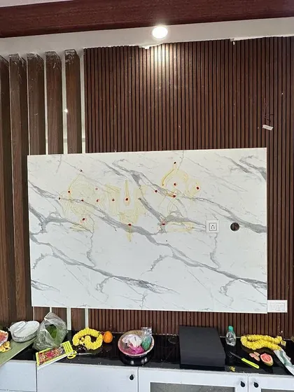 A work-in-progress shot of a TV unit installation. The combination of a marble-finish panel and fluted wood accents demonstrates our approach to mixing materials for a contemporary and textured look.