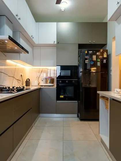 The kitchen in the Murlis' home, featuring a modern two-tone design with glossy brown and white cabinets, complemented by a striking marble-veined backsplash.