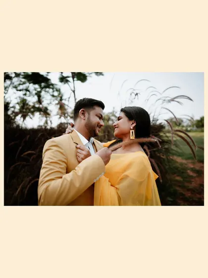 An intimate portrait of the couple in a field of tall grass, their faces close as they share a private smile.