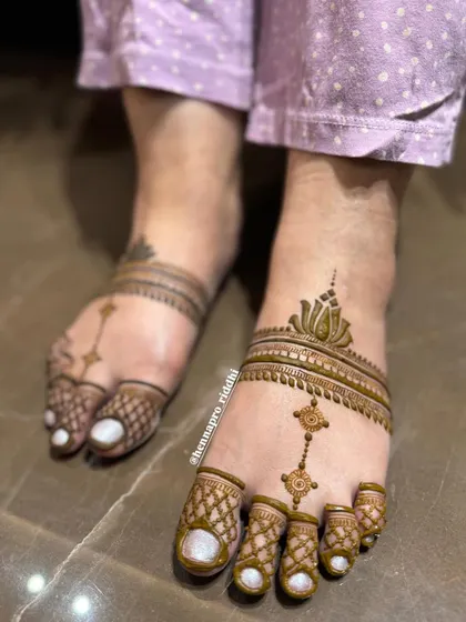 Another take on a minimal leg design. This elegant pattern features a lotus motif and a delicate chain-like design running down the foot, creating a very graceful look.