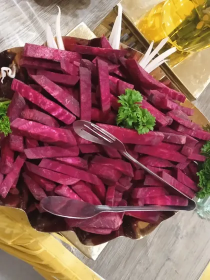 A bowl of vibrant beetroot sticks, garnished with parsley and carved radish, adding color and nutrition to the buffet.
