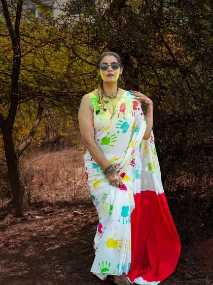 A stylish portrait from a Holi-themed fashion shoot. The colorful handprints on the saree create a unique and festive look, blending tradition with modern fashion sensibilities.