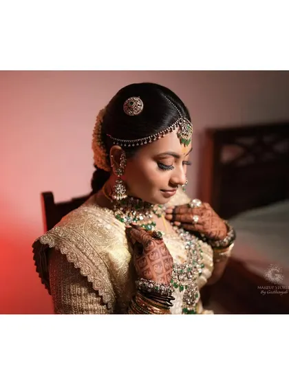 A soft and artistic portrait of Nidhi. This shot captures the intricate details of her hand-embroidered blouse and the delicate shimmer of her eye makeup.