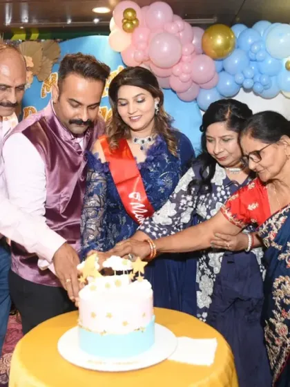 The family gathers around the mom-to-be to help her cut the cake, a central moment of the celebration.