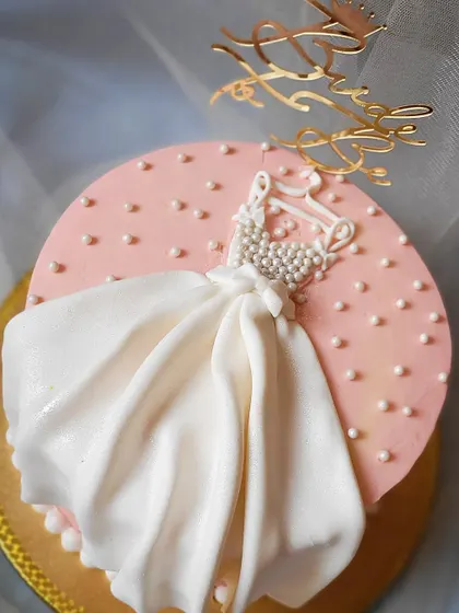 The perfect cake for the perfect bride-to-be. This design features a delicate fondant dress on a hanger, perfect for a bridal shower.