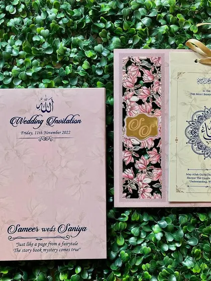 A beautiful Nikah invitation in pastel pink with a floral design. The main insert features stunning Arabic calligraphy and is tied with a ribbon.