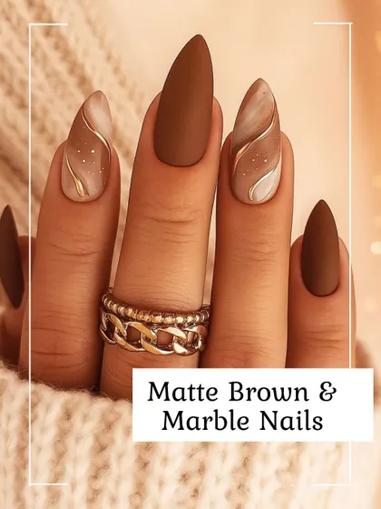 A sophisticated look featuring almond-shaped nails with a combination of solid matte brown and delicate marble art. The accent nails include soft white and brown swirls, highlighted with a fine gold line for a touch of luxury.