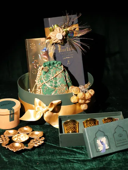 The complete corporate gifting set for DC Group, including a large hamper, a set of votives, and a smaller gift box, all unified by a luxurious green and gold theme.