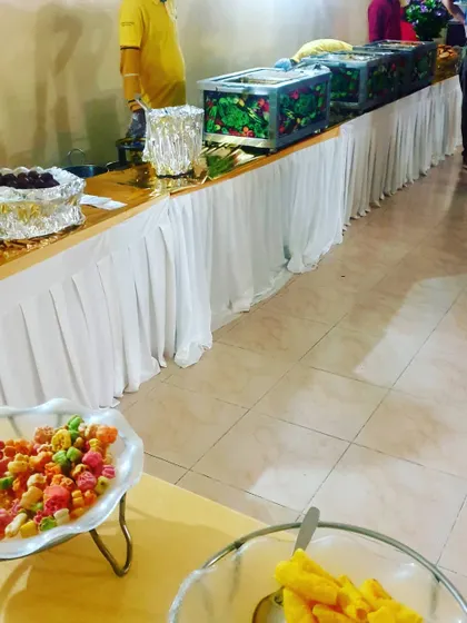 A simple yet elegant buffet line with clean white table skirting. This setup is perfect for house parties, kitty parties, or smaller social gatherings.