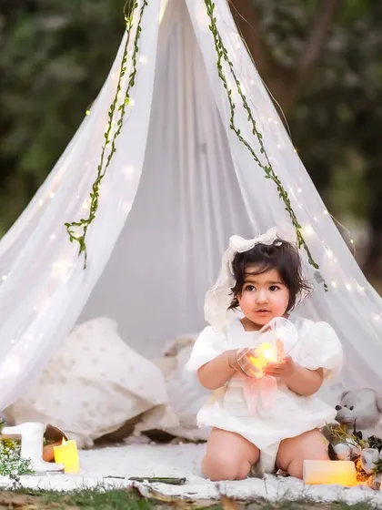 We can take the magic outdoors. This dreamy pre-birthday session features a beautiful tent and fairy light setup in a Delhi NCR garden, creating a truly enchanting memory.