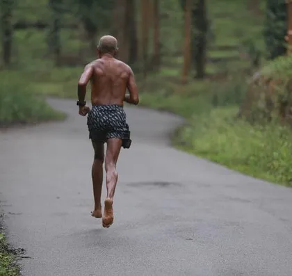 A lone runner in his element, flying across the pavement. This image captures the pure freedom and power of barefoot running.