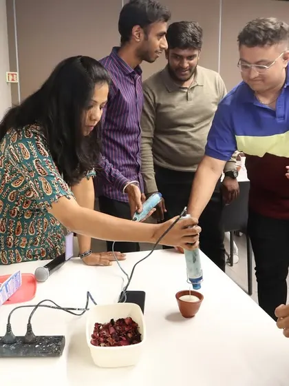 A participant gets hands-on experience, using a heat gun to ensure a smooth finish on their candle. Our workshops are interactive, allowing team members to learn and apply new crafting techniques.