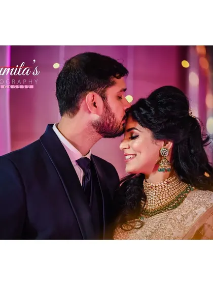 A tender forehead kiss, a timeless expression of love. This intimate shot from their reception captures the couple's affection in a beautifully lit moment.