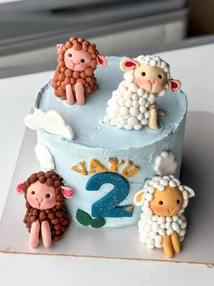 A slightly different angle of the sweet sheep-themed birthday cake.
