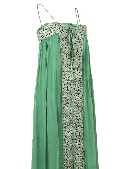A side-angle view of the green embroidered maxi dress, showing the flow of the fabric and the tie-up detail at the neckline.