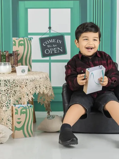 This little boy is all smiles during his Starbucks-themed session, ready to take your order.