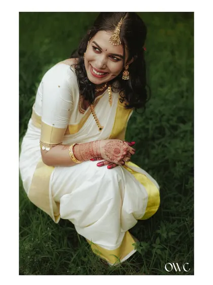A playful and happy portrait of the bride crouching in the grass.