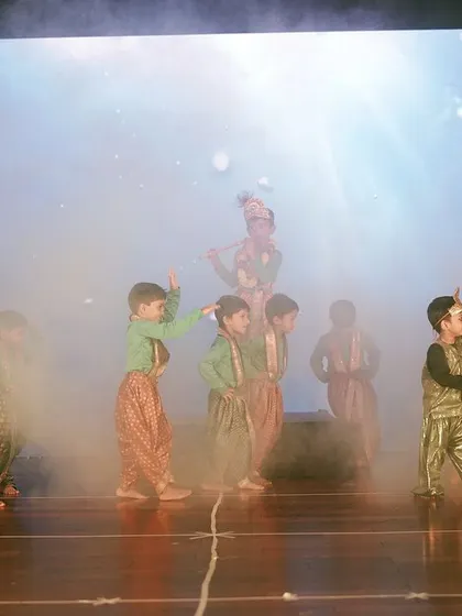 I use professional stage effects like smoke machines and dynamic LED backdrops to create a theatrical experience for annual day performances. This moment from a Maple Bear event highlights the production quality I bring to school stage shows.