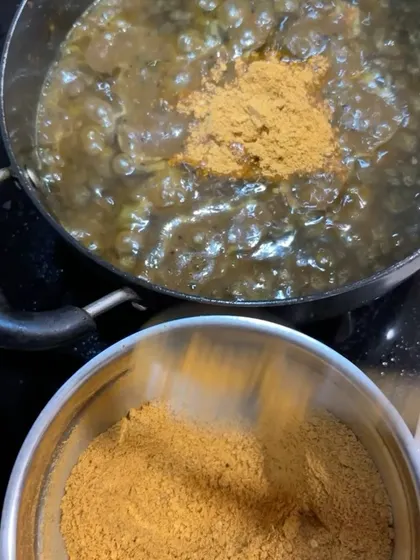 Here you can see my homemade spice powder being added to a simmering base. This is a key step in creating the authentic flavour profile of my Puliogare mix.