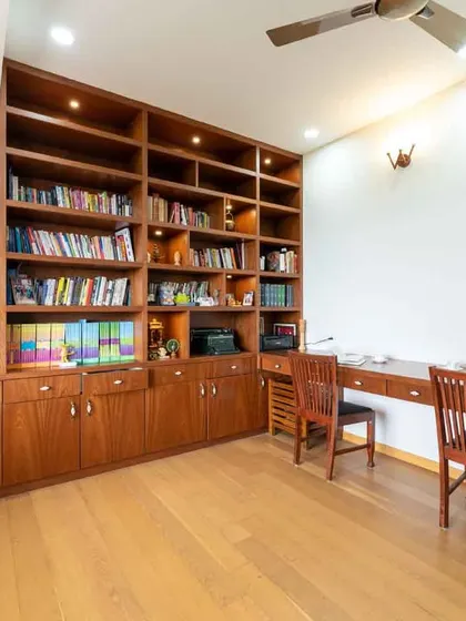 For the book-loving family, we designed this home office and library with a floor-to-ceiling bookshelf. The rich wood finish and integrated lighting create a warm and inviting atmosphere for work or study.