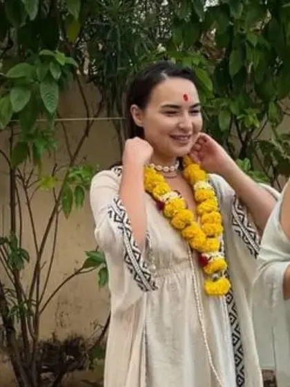 Two students share a lighthearted moment during the opening ceremony, helping each other with their marigold garlands. This captures the friendships that blossom at our retreats.