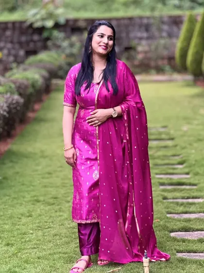 Prathiksha in her pink salwar suit, captured in a beautiful garden setting.