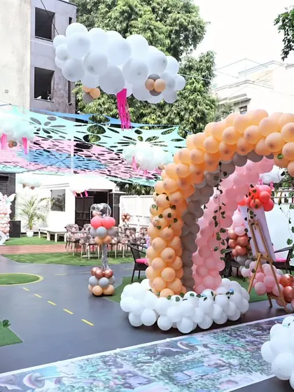 A fairytale theme party setup in our outdoor area. The rainbow balloon arch and cloud decorations create a magical sky for a whimsical celebration.