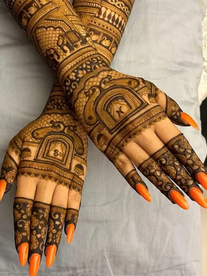 A clearer view of the matching hands, showing the symmetry and detail in the elephant and architectural patterns. The couple's initials, 'K' and 'S', are featured prominently.