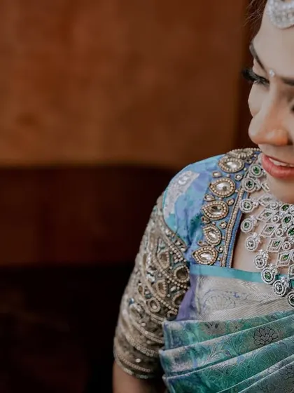 A close-up on the stunning details of this reception attire. The intricate beadwork on the blouse and the heavy diamond necklace are paired with equally detailed and glamorous makeup.