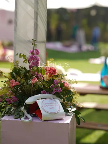Another fun, personalized prop from the Valentine's event. A vintage telephone labeled "For love emergencies only" was nestled in a floral arrangement, adding to the event's unique and playful character.