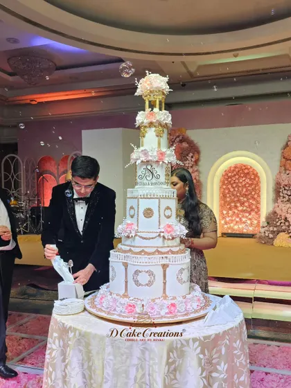 The couple prepares to cut their magnificent multi-tiered engagement cake. This shot captures the scale and grandeur of the cake within the context of the celebration.