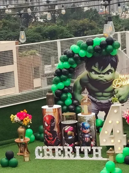 This view showcases the full Avengers birthday setup, including the balloon arch and personalized name sign, set against the city skyline.