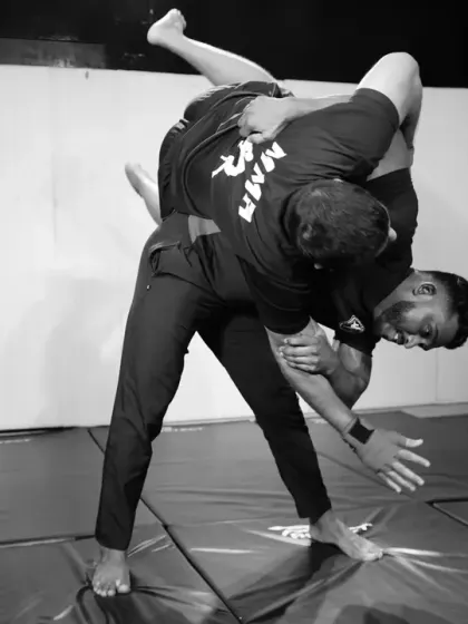 The peak of a takedown execution. This dynamic shot demonstrates the power and technique required to unbalance and control an opponent in a grappling exchange.