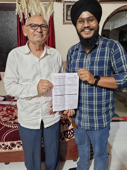 An elderly customer holds his new solar agreement, presented by our team.