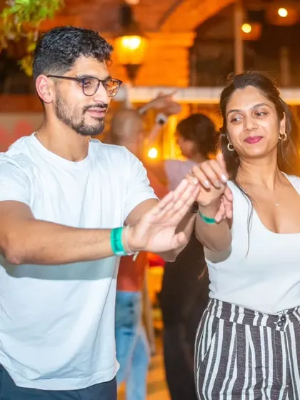 A stylish pair showing off their moves. The striped pants and white top make for a classic dance look.