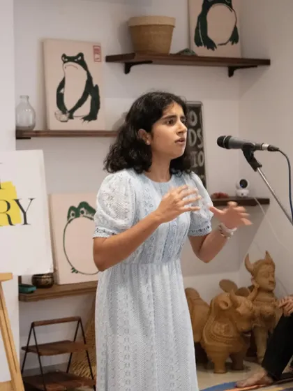 A young performer confidently taking the mic. We encourage artists of all ages to participate and share their unique perspectives with our supportive audience.