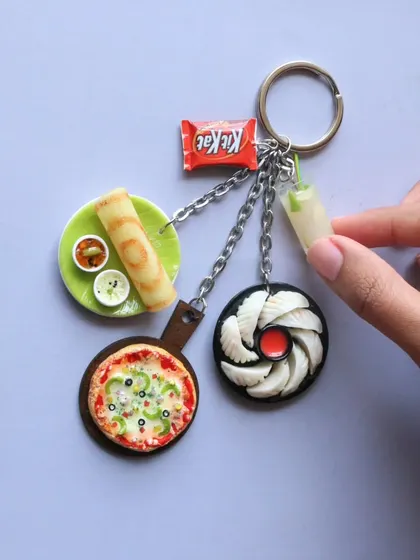 An assorted keychain featuring a variety of foods, including pizza, dosa, momos, and KitKat.